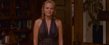Movie still from “The Proposal” (2009), directed by Anne Fletcher – A woman standing in front of a door wearing a blue and brown dress; Medium shot, Over the shoulder angle