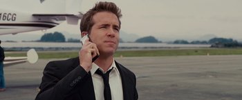 Movie still from “The Proposal” (2009), directed by Anne Fletcher – A man wearing a suit and tie talking on a cell phone; Close Up shot, Low angle