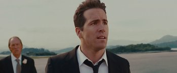 Movie still from “The Proposal” (2009), directed by Anne Fletcher – A person wearing a suit and tie; Close Up shot, Low angle