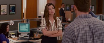 Movie still from “The Proposal” (2009), directed by Anne Fletcher – A woman standing with her arms crossed in an office setting; Medium shot, Over the shoulder angle