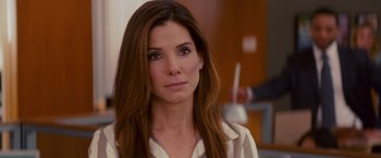 Movie still from “The Proposal” (2009), directed by Anne Fletcher – A woman with long brown hair wearing a white shirt; Close Up shot, Over the shoulder angle