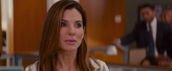 Movie still from “The Proposal” (2009), directed by Anne Fletcher – A woman with long brown hair looking at the camera; Close Up shot, Over the shoulder angle