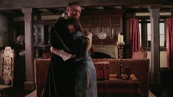 Movie still from “Ella Enchanted” (2004), directed by Tommy O'Haver – A man and a woman hugging in a living room; Medium shot, Over the shoulder angle