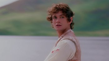 Movie still from “Ella Enchanted” (2004), directed by Tommy O'Haver – A young man with curly brown hair standing in front of a body of water; Close Up shot, Over the shoulder angle
