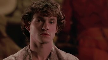 Movie still from “Ella Enchanted” (2004), directed by Tommy O'Haver – A young man with curly brown hair stares into the camera; Close Up shot, Over the shoulder angle