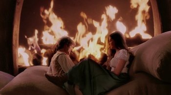 Movie still from “Ella Enchanted” (2004), directed by Tommy O'Haver – Two women sitting on a couch in front of a fire; Wide shot, High angle