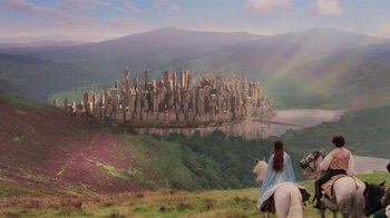 Movie still from “Ella Enchanted” (2004), directed by Tommy O'Haver – A man riding on the back of a white horse next to a city; Extreme Wide shot, High angle