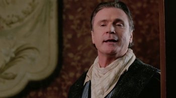 Movie still from “Ella Enchanted” (2004), directed by Tommy O'Haver – An older man wearing a black jacket and a white neck scarf; Close Up shot, Low angle