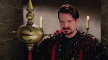 Movie still from “Ella Enchanted” (2004), directed by Tommy O'Haver – A man with a beard wearing a black and red outfit; Close Up shot, Over the shoulder angle