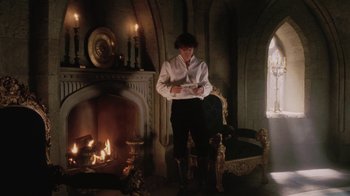 Movie still from “Ella Enchanted” (2004), directed by Tommy O'Haver – A man standing in front of a fire place; Wide shot, High angle