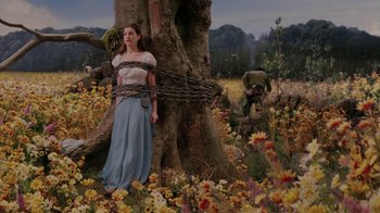 Movie still from “Ella Enchanted” (2004), directed by Tommy O'Haver – A woman chained to a tree with a chain around her neck; Wide shot, Low angle