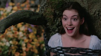Movie still from “Ella Enchanted” (2004), directed by Tommy O'Haver – A young woman is smiling while hanging from a tree branch; Close Up shot, Overhead angle