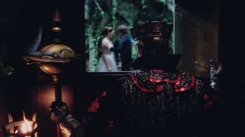 Movie still from “Ella Enchanted” (2004), directed by Tommy O'Haver – A woman in a red and black dress looking out a window; Medium shot, Over the shoulder angle
