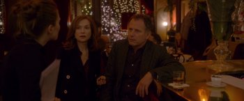 Movie still from “Elle” (2016), directed by Paul Verhoeven – A man and a woman sitting at a table in a restaurant; Medium shot, Over the shoulder angle