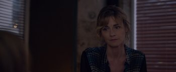 Movie still from “Elle” (2016), directed by Paul Verhoeven – A person sitting in a room; Close Up shot, Over the shoulder angle