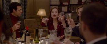 Movie still from “Elle” (2016), directed by Paul Verhoeven – A group of people sitting around a table with wine glasses; Medium shot, Over the shoulder angle
