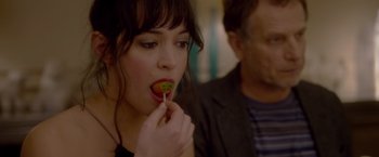 Movie still from “Elle” (2016), directed by Paul Verhoeven – A woman holding a lollipop in front of a man's face; Close Up shot, Over the shoulder angle