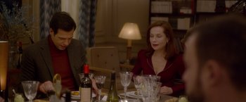 Movie still from “Elle” (2016), directed by Paul Verhoeven – Two women sitting at a dinner table with wine glasses; Medium shot, Over the shoulder angle