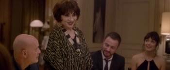 Movie still from “Elle” (2016), directed by Paul Verhoeven – An older woman standing in front of a man; Medium shot, Over the shoulder angle