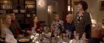 Movie still from “Elle” (2016), directed by Paul Verhoeven – A group of people sitting around a table with wine glasses; Medium shot, Over the shoulder angle