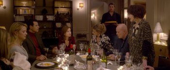 Movie still from “Elle” (2016), directed by Paul Verhoeven – A group of people sitting at a table with wine glasses; Medium shot, Over the shoulder angle