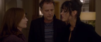 Movie still from “Elle” (2016), directed by Paul Verhoeven – A man and a woman standing next to each other in a room; Close Up shot, Over the shoulder angle