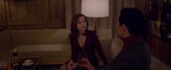 Movie still from “Elle” (2016), directed by Paul Verhoeven – A woman sitting on a couch holding a glass of wine; Medium shot, Over the shoulder angle