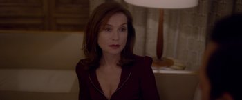 Movie still from “Elle” (2016), directed by Paul Verhoeven – A person sitting in a room; Close Up shot, Over the shoulder angle