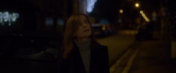 Movie still from “Elle” (2016), directed by Paul Verhoeven – A woman standing on the side of a road at night; Close Up shot, Low angle