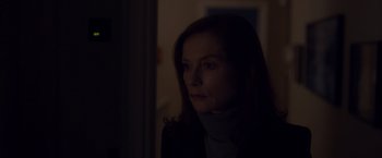 Movie still from “Elle” (2016), directed by Paul Verhoeven – A woman in a dark room looking at the camera; Close Up shot, Low angle