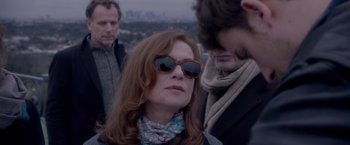 Movie still from “Elle” (2016), directed by Paul Verhoeven – A group of people standing next to each other on top of a hill; Close Up shot, Over the shoulder angle