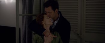 Movie still from “Elle” (2016), directed by Paul Verhoeven – A man and a woman kissing in front of a window; Close Up shot, Low angle