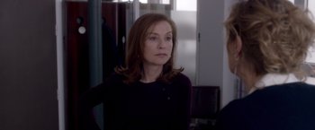 Movie still from “Elle” (2016), directed by Paul Verhoeven – A person wearing a black shirt; Close Up shot, Over the shoulder angle