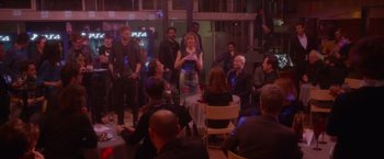 Movie still from “Elle” (2016), directed by Paul Verhoeven – A group of people sitting around a room; Wide shot, Over the shoulder angle