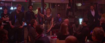 Movie still from “Elle” (2016), directed by Paul Verhoeven – A group of people sitting at a table with drinks; Wide shot, Over the shoulder angle