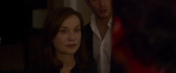 Movie still from “Elle” (2016), directed by Paul Verhoeven – A woman standing next to a man in a room; Close Up shot, Over the shoulder angle