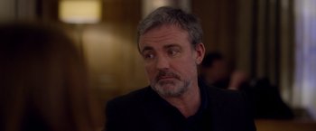 Movie still from “Elle” (2016), directed by Paul Verhoeven – A person wearing a suit and tie; Close Up shot, Over the shoulder angle