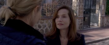 Movie still from “Elle” (2016), directed by Paul Verhoeven – A woman is talking to another woman outside; Close Up shot, Over the shoulder angle