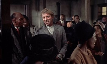 Movie still from “Elmer Gantry” (1960), directed by Richard Brooks – A group of people sitting in a room; Medium shot, Over the shoulder angle