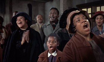Movie still from “Elmer Gantry” (1960), directed by Richard Brooks – A group of people standing next to each other in a room; Medium shot, Low angle