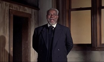 Movie still from “Elmer Gantry” (1960), directed by Richard Brooks – An older man wearing a suit and a tie; Medium shot, Low angle