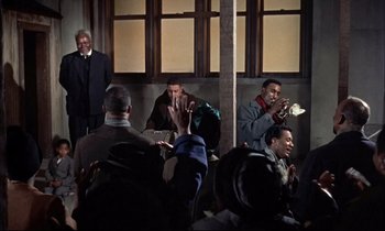 Movie still from “Elmer Gantry” (1960), directed by Richard Brooks – A group of people standing around a building; Medium shot, High angle