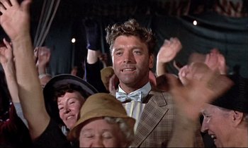 Movie still from “Elmer Gantry” (1960), directed by Richard Brooks – A group of people that are standing in a room; Medium shot, Low angle