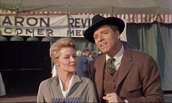 Movie still from “Elmer Gantry” (1960), directed by Richard Brooks – An older man and a woman standing next to each other; Medium shot, Low angle