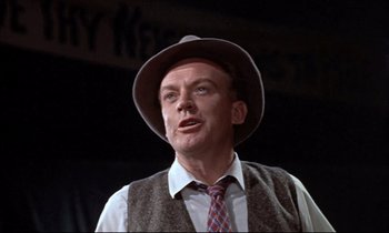 Movie still from “Elmer Gantry” (1960), directed by Richard Brooks – An older man wearing a hat and a tie; Close Up shot, Low angle