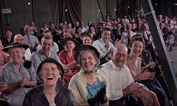 Movie still from “Elmer Gantry” (1960), directed by Richard Brooks – A group of older people sitting in a crowd clapping; Wide shot, High angle