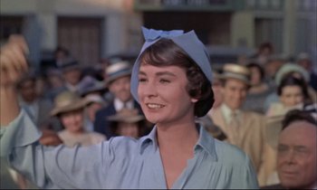 Movie still from “Elmer Gantry” (1960), directed by Richard Brooks – A woman wearing a blue hat and a blue shirt; Medium shot, Low angle
