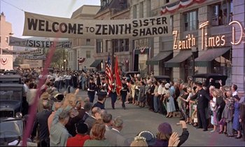 Movie still from “Elmer Gantry” (1960), directed by Richard Brooks – A crowd of people watching a parade on a city street; Wide shot, High angle