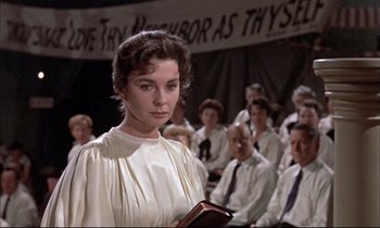 Movie still from “Elmer Gantry” (1960), directed by Richard Brooks – A woman standing in front of a group of people; Close Up shot, Over the shoulder angle