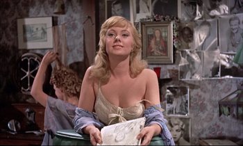 Movie still from “Elmer Gantry” (1960), directed by Richard Brooks – A woman sitting in a chair holding a magazine; Medium shot, Over the shoulder angle